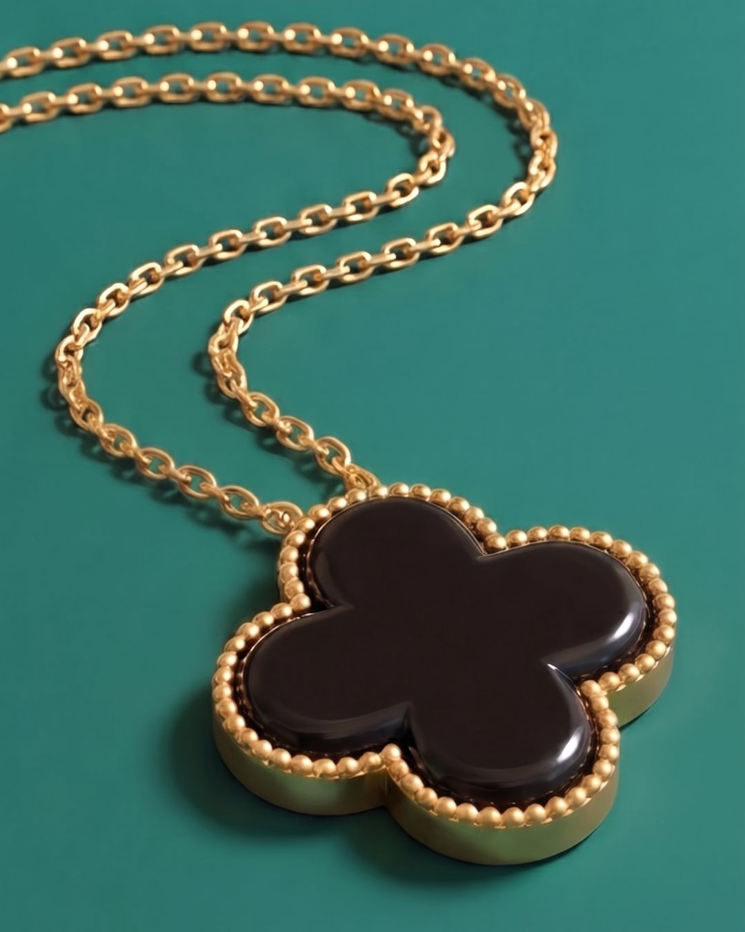 Collar trébol sobre fondo turquesa, producto editorial Coralia